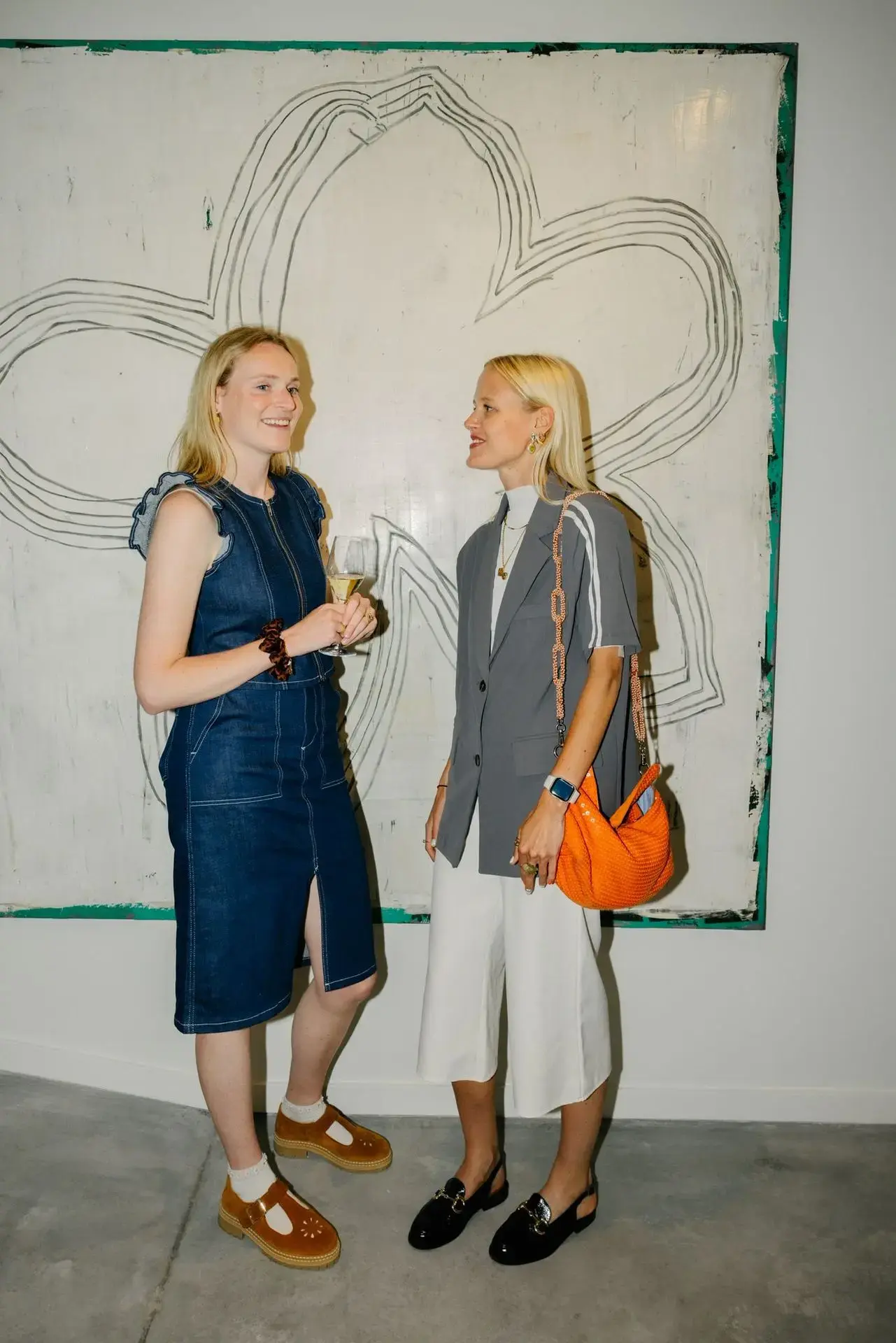 Two guests chatting in front of a contemporary artwork at The Nestwork in Brussels